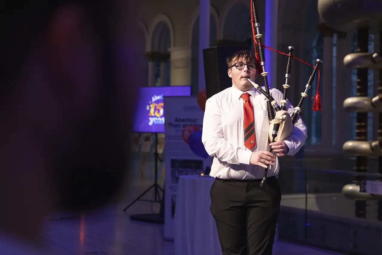 A young man playing bagpipes at Aberlour's 150th anniversary celebration