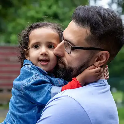 A father holding his young daughter close