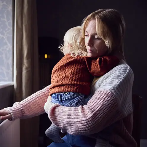 A mother holding her young child at home