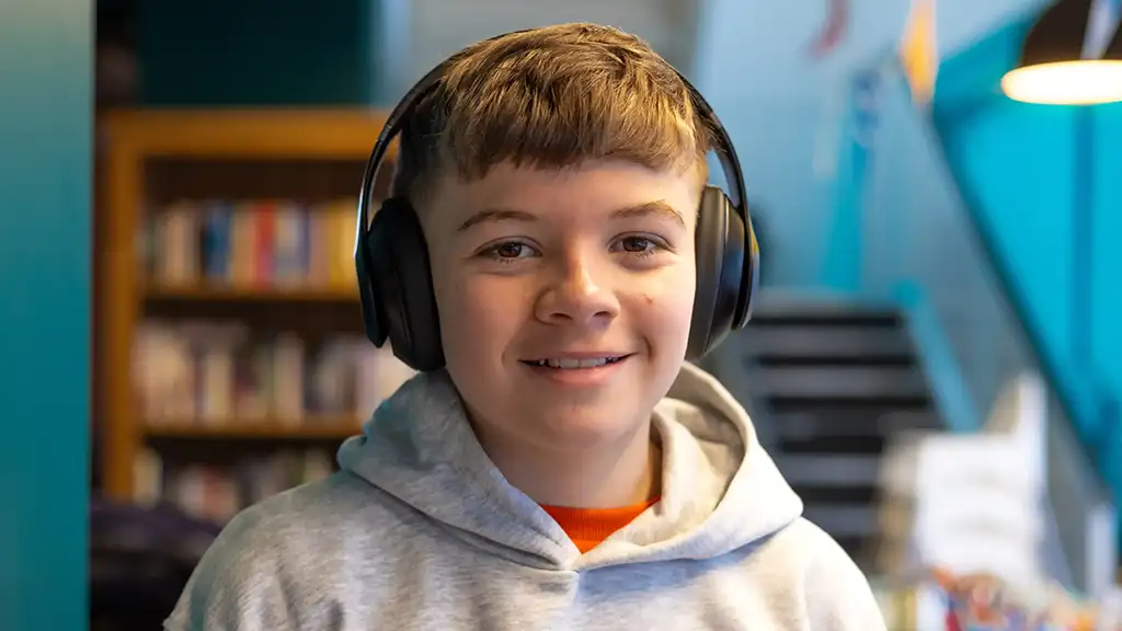 A young person wearing headphones, supported by Aberlour's Primary Years Outreach service